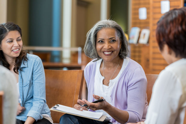 women patient writing on a clipboard in medical waiting room