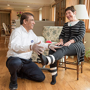 Home health care staff member helping woman