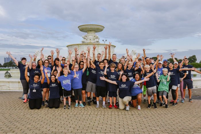 group of people at fundraiser raising their hands