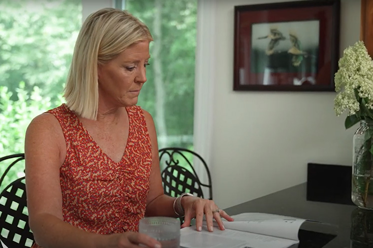 Karen sitting at kitchen table reading