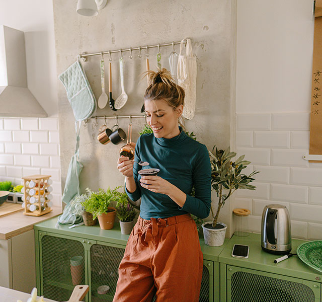 person standing and eating in kitchen