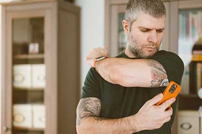 man checking blood sugar on smart phone