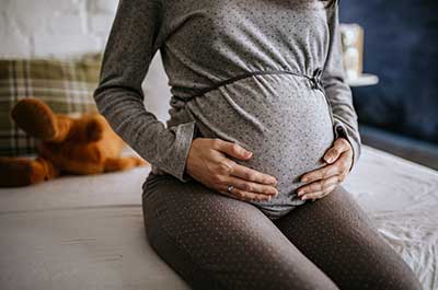 pregnant woman sitting on bed
