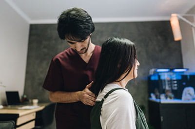 A care giver placing their hand on a patients back with pressure