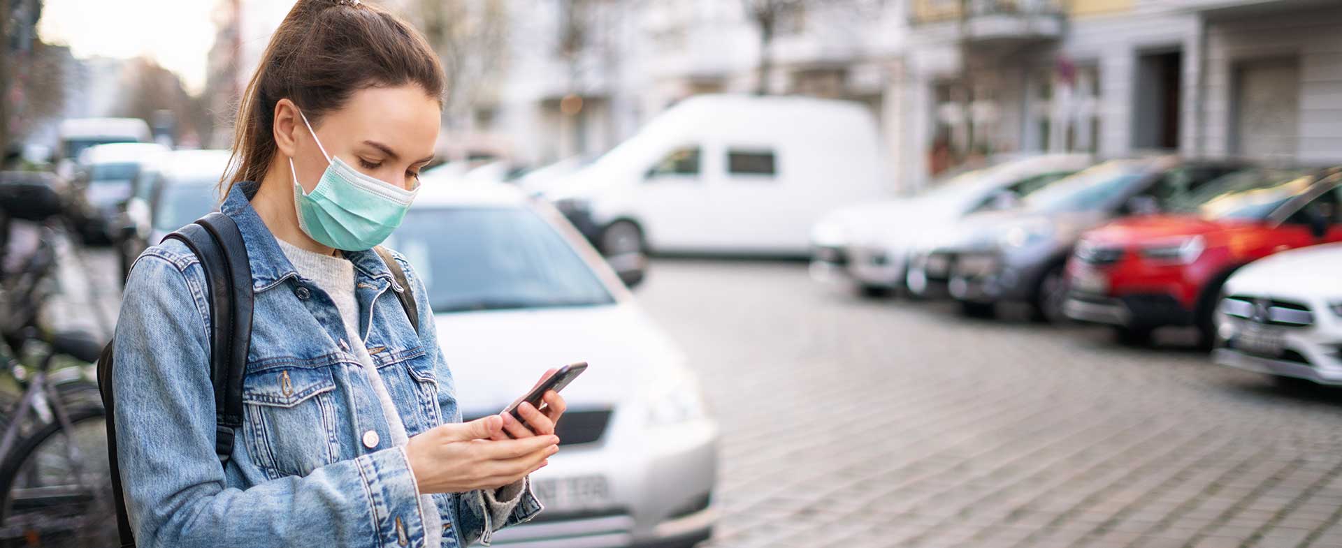 woman in mask scrolling on phone