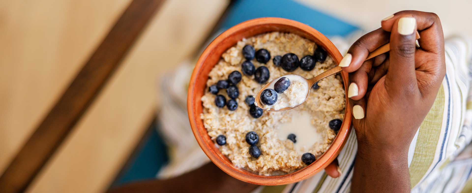Person eating oatmeal with blueberries. dummy desktop Image