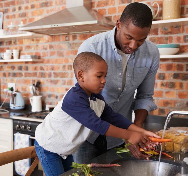 father and son washing vegetables