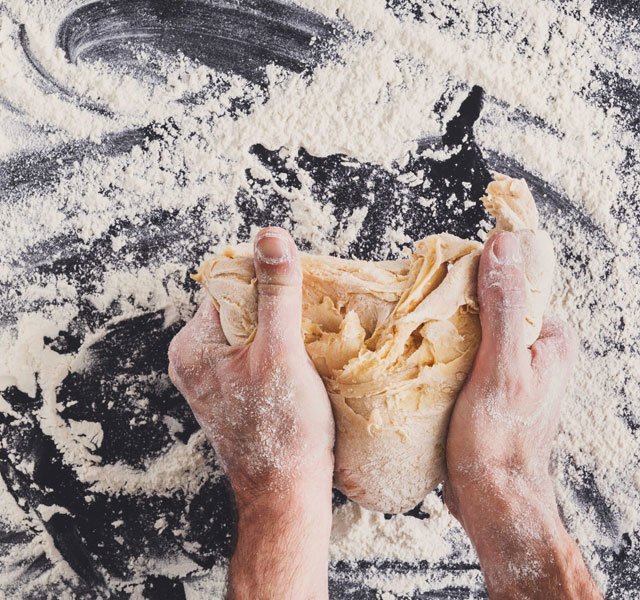 hands kneading bread dough