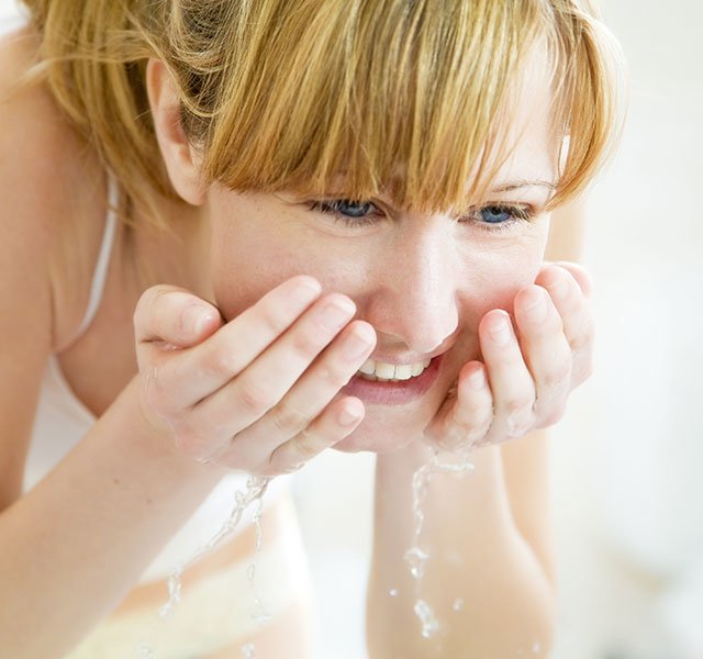 woman washing her face