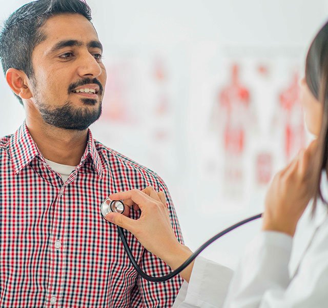 Female doctor listening to mans heart