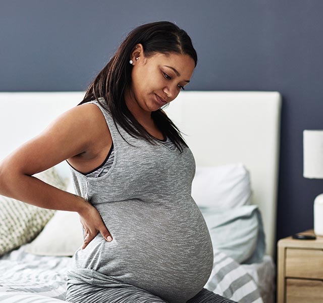 pregnant woman sitting on bed