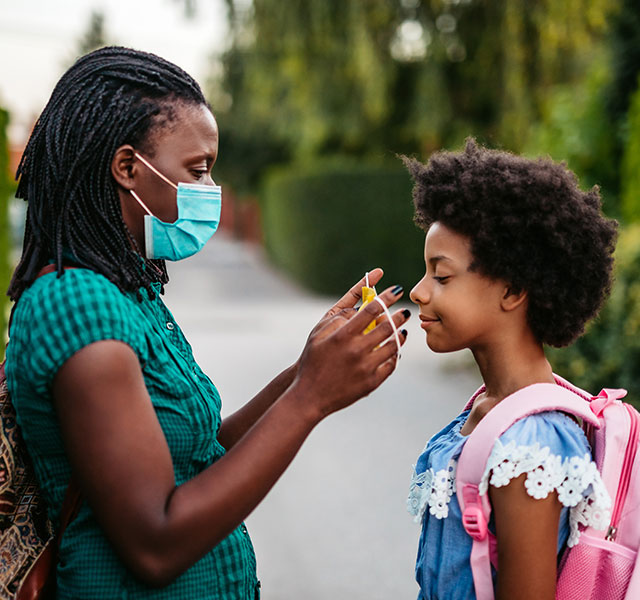 mom putting mask on daughter