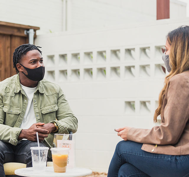 two people in masks talking