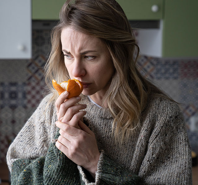 woman smelling orange