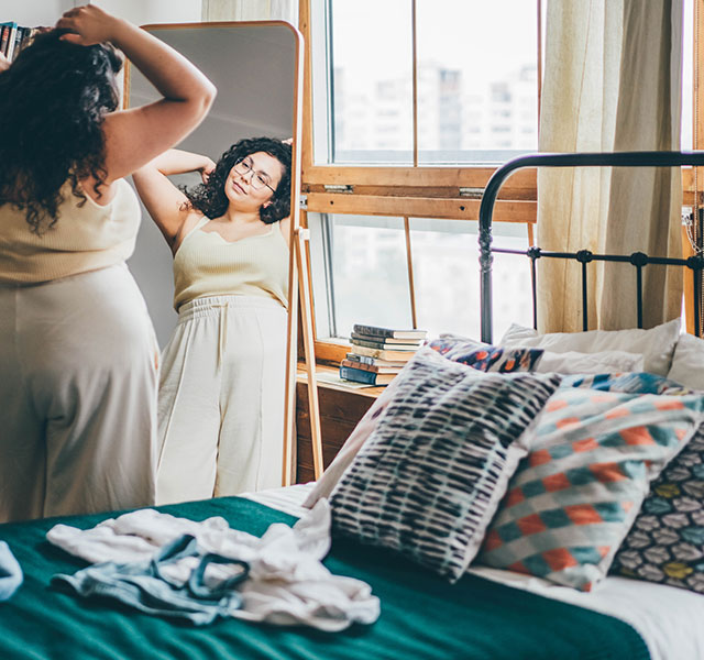 woman standing in front of mirror