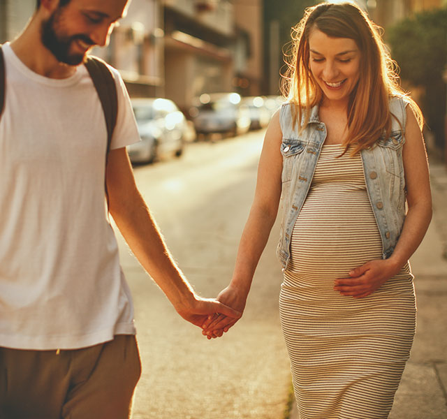pregnant couple walking outside