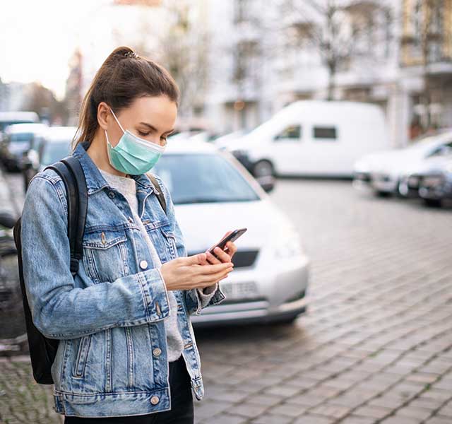 woman in mask scrolling on phone