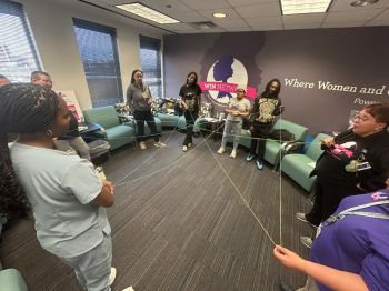A community health worker leads an interactive group activity with participants during WIN Network group prenatal care, encouraging connection, teamwork, and engagement.