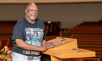 Reverend Anthony posed inside his church at the speaking podium
