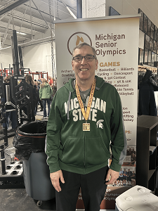 Jeff Ellis stands wearing his gold medal he won at the Michigan Senior Olympics.